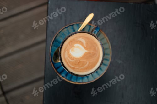 Preview: Top view of blue latte coffee cup with natural art. Hot coffee latte with latte art milk foam in