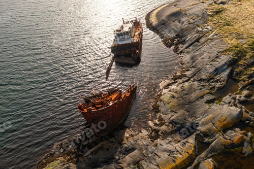 Preview: Remains of a submerged vessel lying close to rugged Norwegian shore.