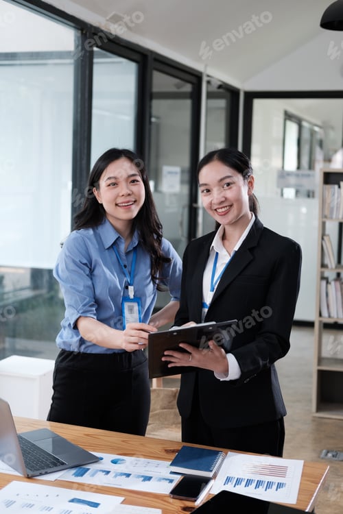 Preview: Smiling young Asian woman talk with female colleagues brainstorm at office team meeting. Teamwork co