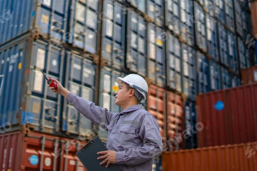 Preview: Blue collar worker is working at container warehouse.