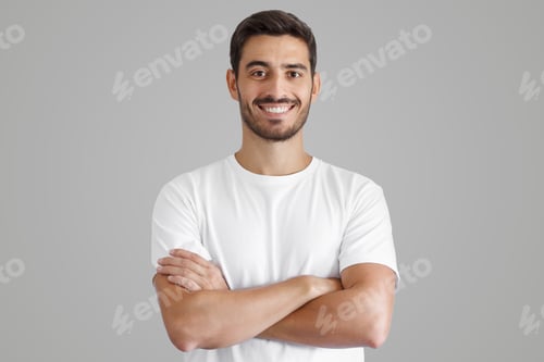 Preview: Portrait of smiling handsome man in white t-shirt, standing with crossed arms