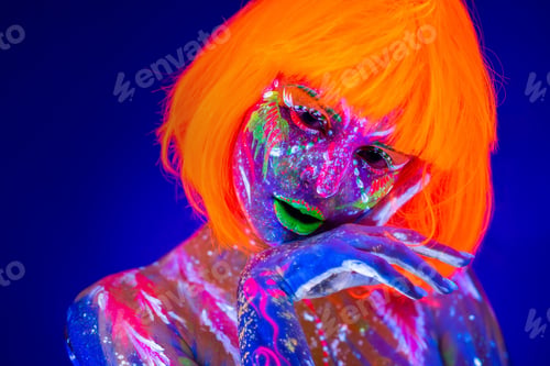 Preview: Close up UV portrait of a female model with artistic colorful makeup and orange wig