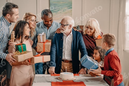 Visualização: família numerosa apresentando bolos e presentes para o avô grisalho
