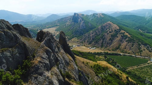 Preview: Top view of a mountainous area with a settlement on a summer day. Shot. Private houses in a village