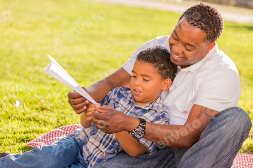 Preview: Mixed Race Father and Son Playing with Paper Airplanes