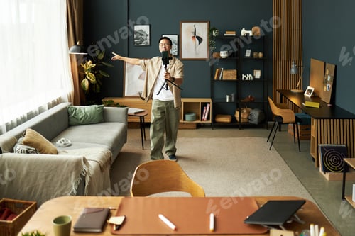 Preview: Young Adult Asian Man Recording Video Content with Smartphone on Tripod Indoors