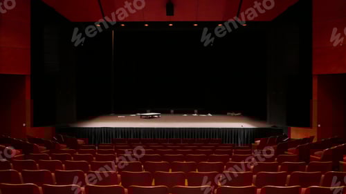 Preview: Empty stage with a few props and red seats