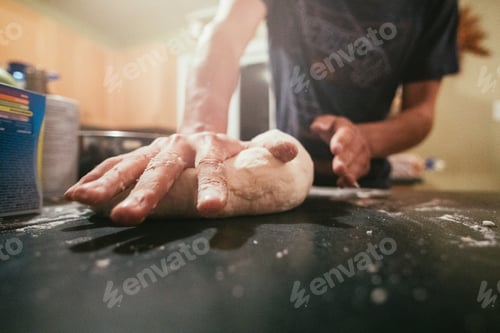 Preview: Closeup shot of a male cook smoothing the dough with flour on his hands