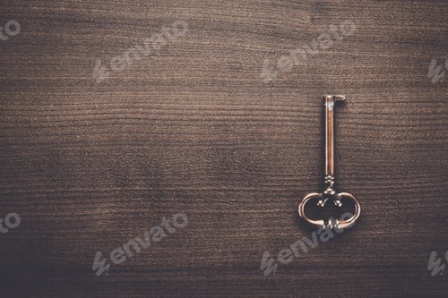 Preview: old brass key on wooden table