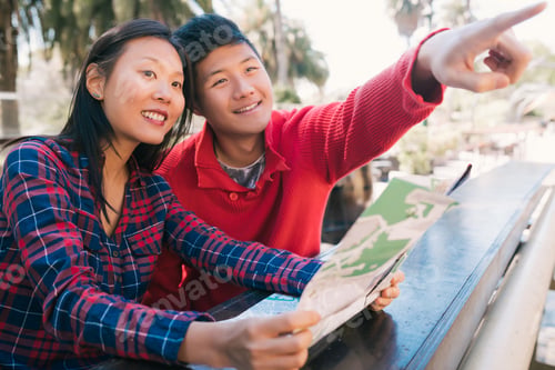 Preview: Asian traveler couple holding a map and looking for directions.