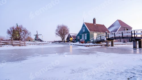 Preview: sunrise at the windmill village Zaanse Schans during winter with snow landscape in the Netherlands