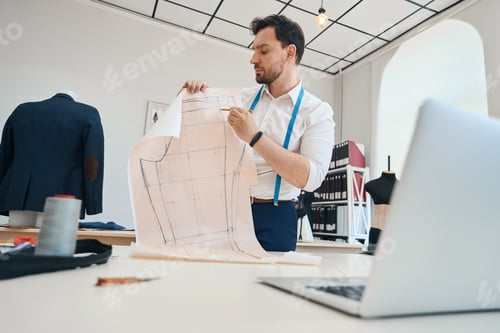 Preview: Male fashion designer communicating online on laptop