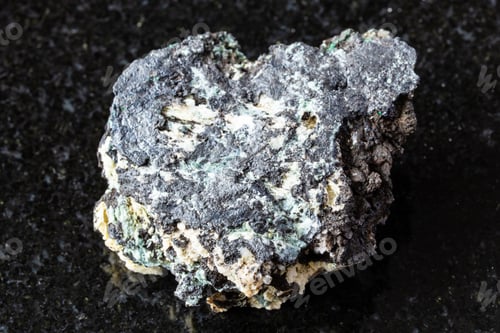 Preview: sample of raw tenorite rock on black granite