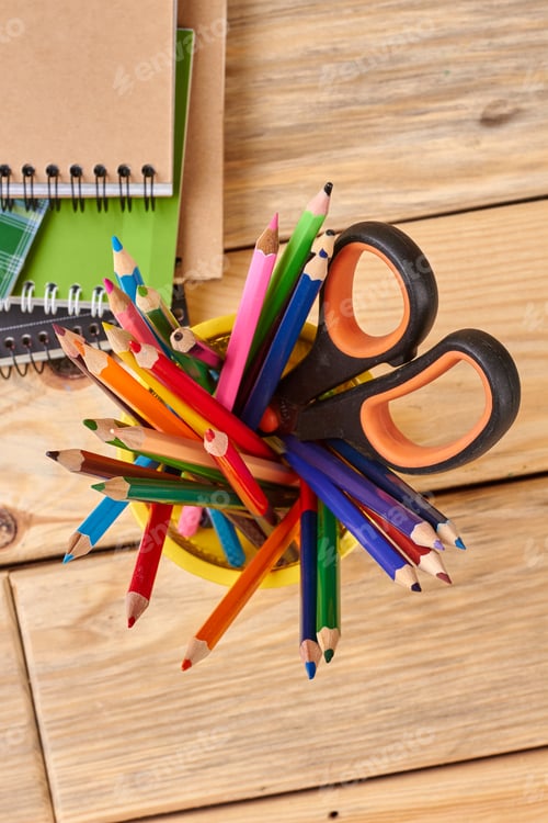 Preview: Multicolored pencils in metal basket, top view.