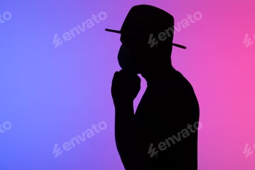 Preview: Silhouette african american man in hat with medical mask against the colourful neon background copy