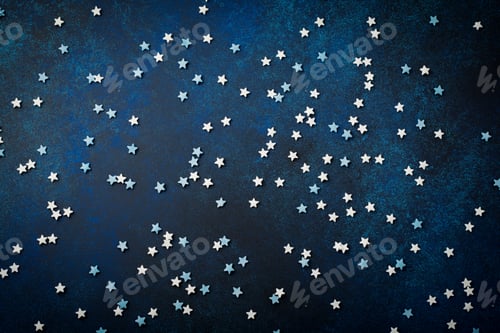 Preview: White and blue small stars of sweets on a dark blue concrete or stone background. Selective focus. C