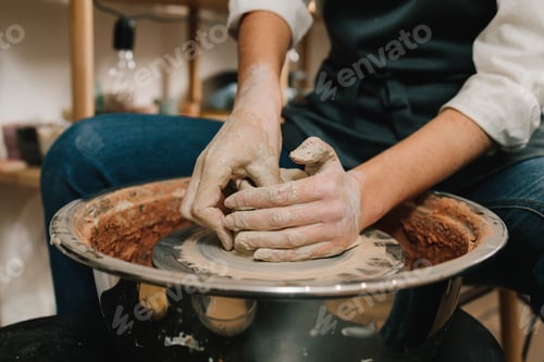 Preview: Making clay earthenware on wheel. Artisan carefully shapes wet clay in studio