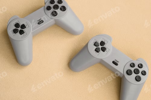 Preview: Playing games concept. Two pad joysticks lies on the blanket of furry orange fleece fabric