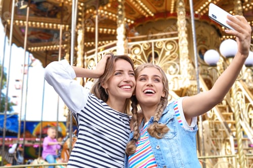 Preview: Attractive women taking selfie in amusement park