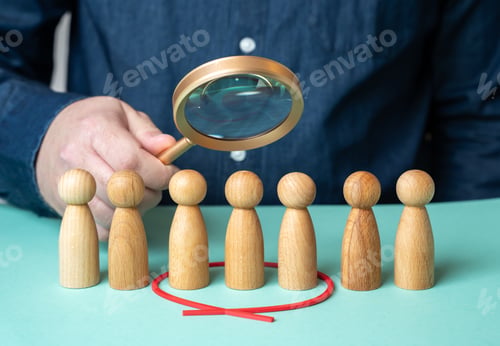 Preview: A man evaluates people figures through a magnifying glass. Search for candidates.