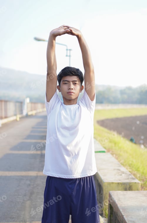 Preview: young asian man having streaching before jogging in the morning