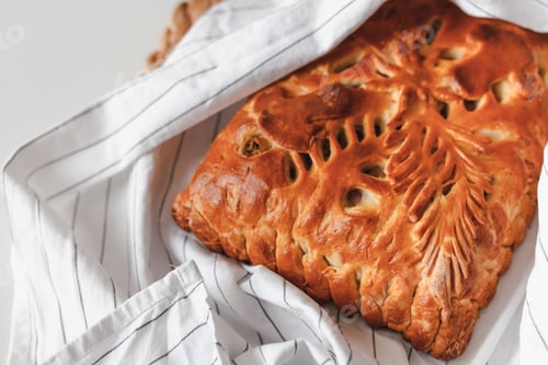 Preview: Homemade baked pie with mushrooms cooling on cloth with copy space. Flat lay, top view