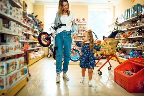 Preview: Mother and little girl buying bicycle, kid's store