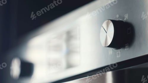 Preview: Close-up of modern plate panel. Concept. Kitchen stove handles with modern stylish design. Metal