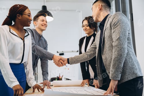 Preview: Diverse businessmen shaking hands after signing contracts at group multiracial meeting