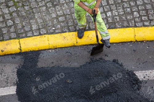 Preview: Worker with a shovel taking a break during the repair of a road