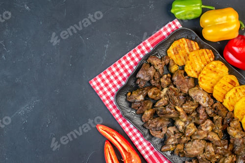 Preview: top view chicken liver fry with potato on platter colored bell peppers on table with free space