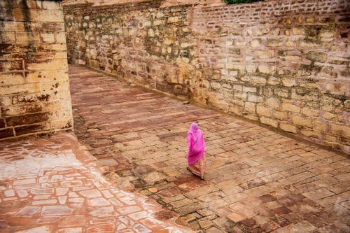 Preview: face covered in traditional dress woman walking on stone street.