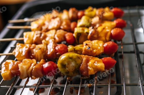 Preview: BBQ grill with a variety of meats, complete with tomatoes and bell peppers.