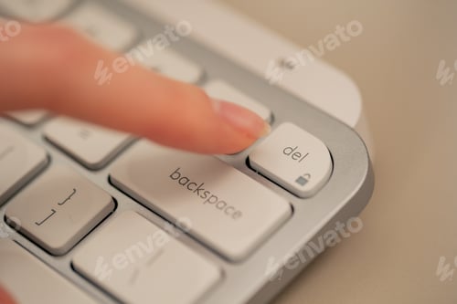 Preview: close-up female young hands pressing the del button on the keyboard office device nude manicure