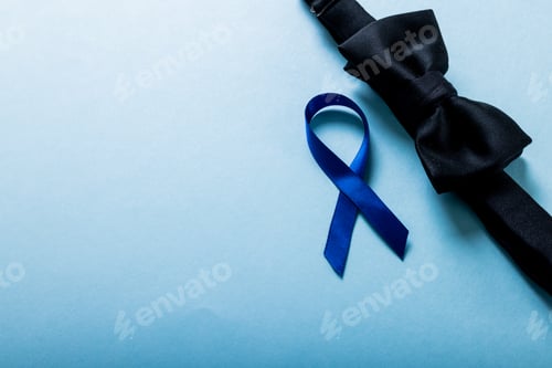 Preview: High angle view of blue prostate cancer awareness ribbon with black bowtie on blue background