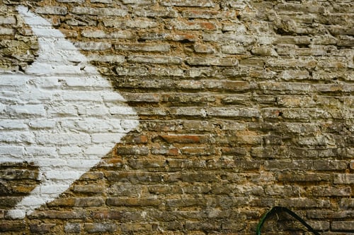 Vista previa: Pared de ladrillo con una gran flecha blanca que indica la dirección, fondo con espacio de copia.