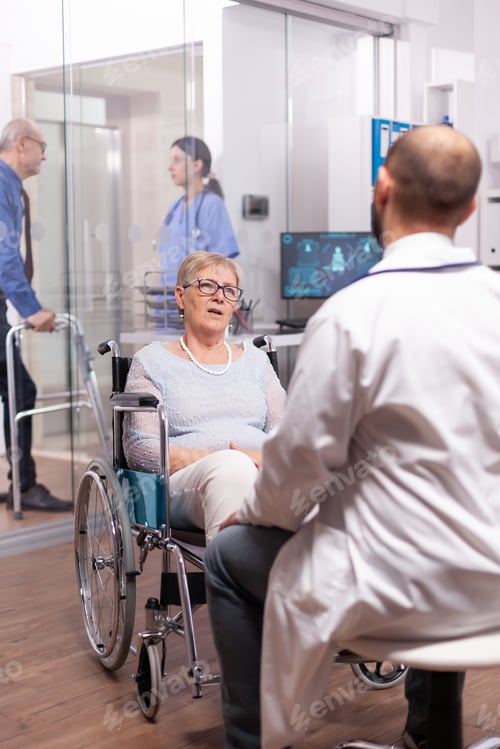 Preview: Paralyzed discussing with geriatrician sitting in wheelchair