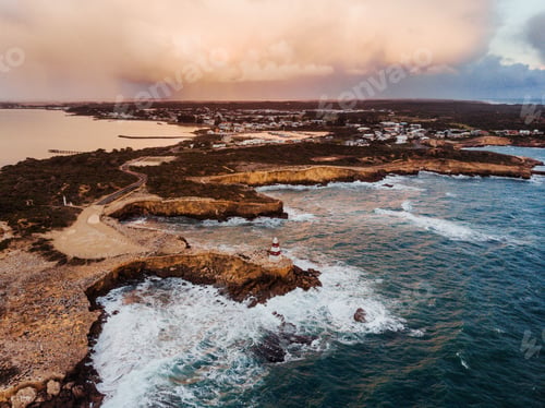 Preview: Aerial shot of Robe Obelisk by the rough sea under a Stormy Sunset in Robe, Australia