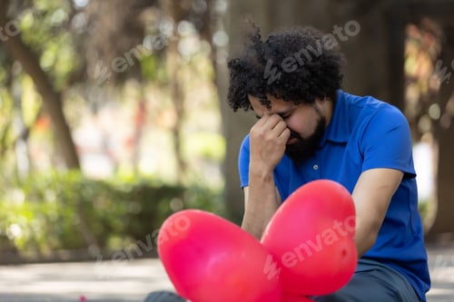 Preview: a man sitting on a bench holding flowers with red balloons