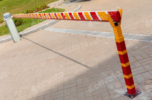 Preview: Yellow and red metal autobarrier, securrity barrier near administrative establishment.