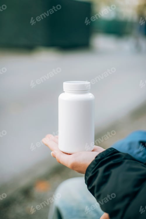 Preview: White Pill Bottle Held Up On City Street