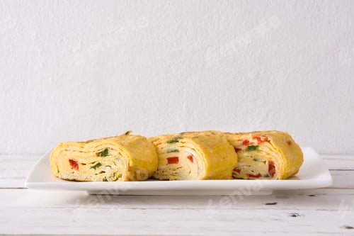 Preview: Tamagoyaki, japanese rolled omelette, sliced and served on white plate