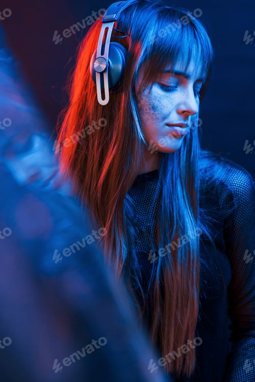 Preview: Attention to details. Studio shot in dark studio with neon light. Portrait of young girl