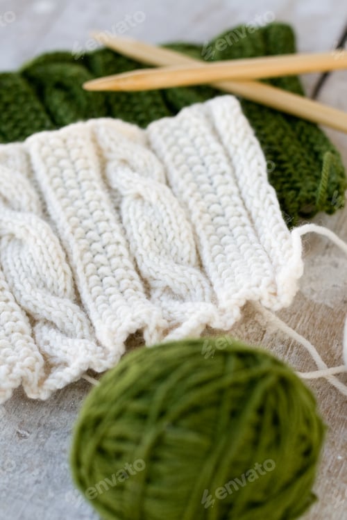 Preview: Knitting pattern and needles on a wooden background