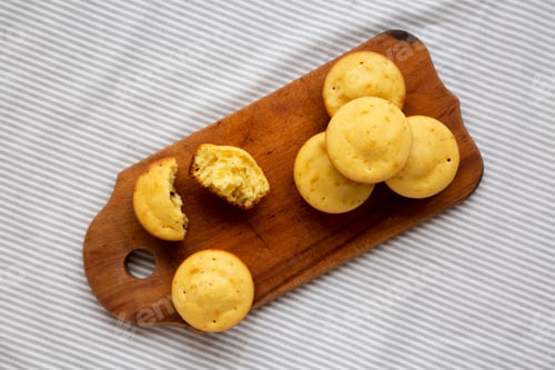 Preview: Homemade Cornbread Muffins on a rustic wooden board, overhead view. Flat lay, from above, top view.