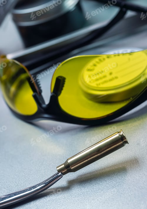 Preview: Bullet casing for analysis together with UV glasses in crime lab, conceptual image