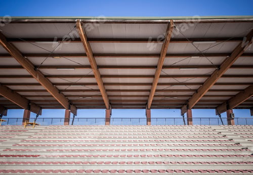 Preview: Sport stadium seating with tin roof against blue sky