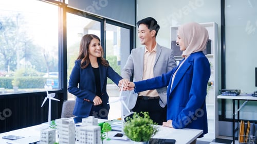 Preview: Three business people gather at a desk, unit with joined hands sustainable solutions for a cleaner