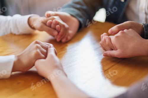 Preview: Group of people sitting in a circle holding hands and pray together or in therapy session