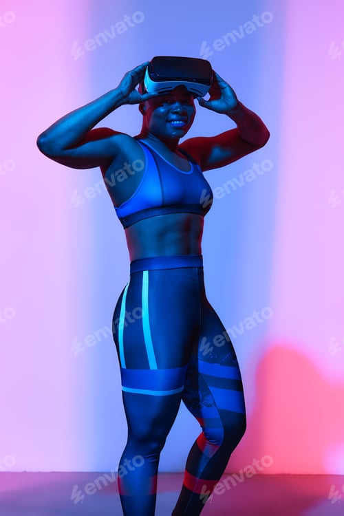 Preview: Modern african black woman with short hiar in sport top and leggings wearing glasses of virtual